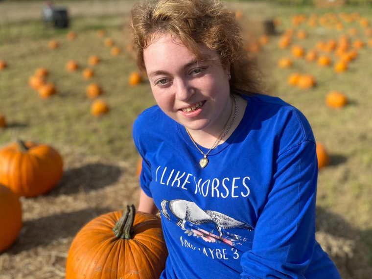 Charlotte, surrounded by pumpkins at Halloween