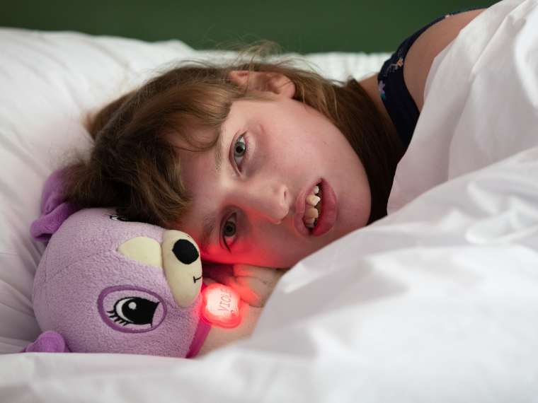 Hannah lies in bed next to her cuddly toy