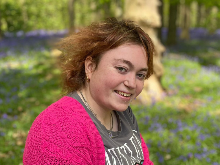 Charlotte surrounded by lavender, looks to camera